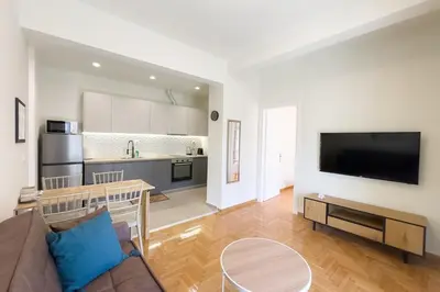 a living room with a couch and a kitchen at Panormou Neon - Urban Apartment 4A in Athens