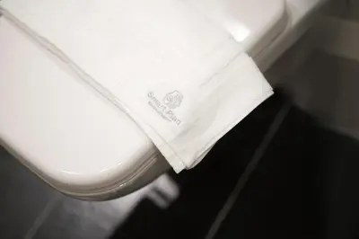a white toilet seat with a towel on it at Panormou Neon - Urban Apartment 4A in Athens