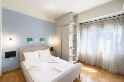 a bedroom with a white bed and a window at Panormou Neon - Urban Apartment 4A in Athens