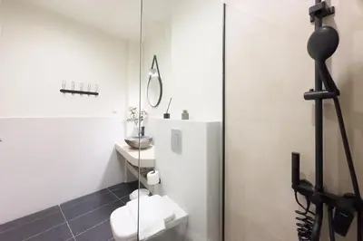 a white bathroom with a toilet and a mirror at Panormou Neon - Urban Apartment 4A in Athens