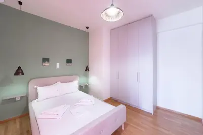 a bedroom with a white bed and a light fixture at Panormou Neon - Urban Apartment 4B in Athens