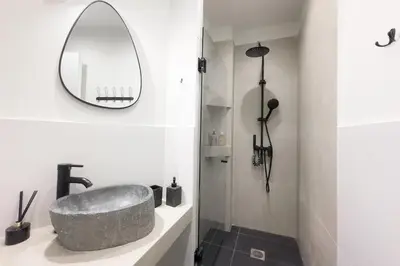 a bathroom with a stone sink and a mirror at Panormou Neon - Urban Apartment 4B in Athens