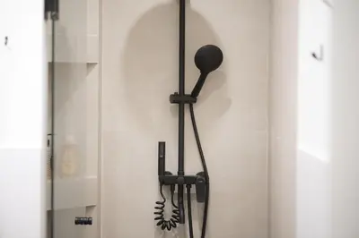 a shower head hanging on a wall in a bathroom at Panormou Neon - Urban Apartment 4B in Athens