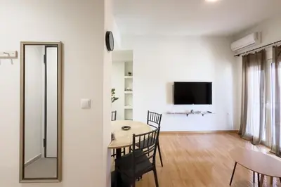 a dining room with a table and chairs and a mirror at Panormou Neon - Urban Apartment 4B in Athens