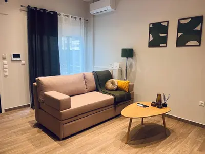 a living room with a couch and a table at Hodos Luxury APT 2 near ATH-Airport in Markopoulo