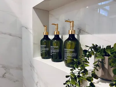 three bottles of wine sitting on a shelf in a bathroom at Hodos Luxury APT 2 near ATH-Airport in Markopoulo