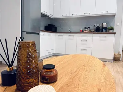 a kitchen with a wooden table and a vase at Hodos Luxury APT 2 near ATH-Airport in Markopoulo