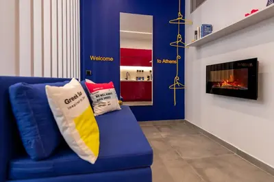 a blue couch with pillows sitting in a living room at Morfes studio at historic center-near Acropolis in Athens
