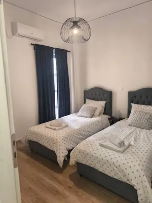 a bedroom with two beds and a chandelier at S-eva resort athens apartments 2 in Athens