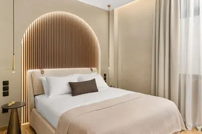 a bedroom with a large bed with a wooden headboard at ESTER Metropolitan Luxe - 2 Bedrooms 2 Bathrooms in Athens