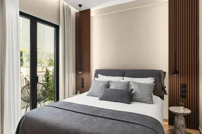 a bedroom with a bed with pillows and a balcony at ESTER Metropolitan Luxe - 2 Bedrooms 2 Bathrooms in Athens