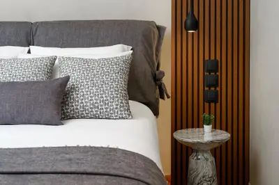 a bed with pillows and a table next to it at ESTER Metropolitan Luxe - 2 Bedrooms 2 Bathrooms in Athens