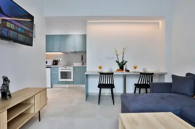 a living room with a blue couch and a kitchen at South Athens Apts New Collection by Live & Travel in Athens