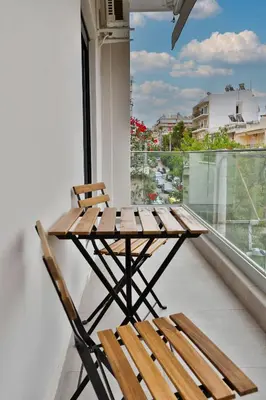a table and chair on a balcony with a view at South Athens Apts New Collection by Live & Travel in Athens