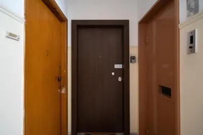 a brown door in a room with two doors at Cozy Apartment in Athens with Balcony, 5 min to Metro in Athens