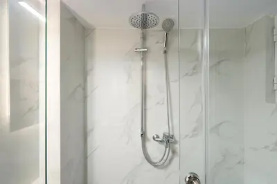 a bathroom with a shower with a glass door at Cozy Apartment in Athens with Balcony, 5 min to Metro in Athens