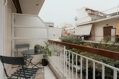 a balcony with a table and chairs on a building at Cozy Apartment in Athens with Balcony, 5 min to Metro in Athens