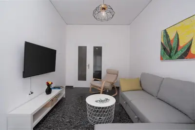 a living room with a couch and a flat screen tv at Cozy Apartment in Athens with Balcony, 5 min to Metro in Athens