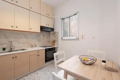 a kitchen with a table and a sink and a counter at Cozy Apartment in Athens with Balcony, 5 min to Metro in Athens