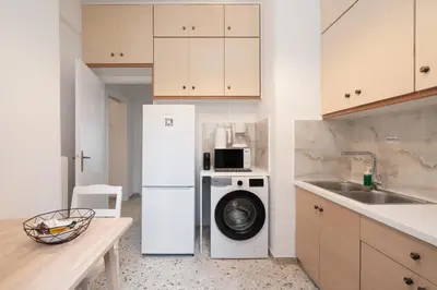 a kitchen with a refrigerator and a washing machine at Cozy Apartment in Athens with Balcony, 5 min to Metro in Athens