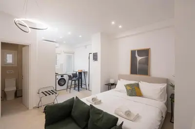 a bedroom with a bed and a living room at 15 mins Walk to Acropolis, Minimalist Studio in Athens