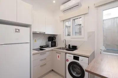 a small kitchen with a washer and dryer in it at 15 mins Walk to Acropolis, Minimalist Studio in Athens