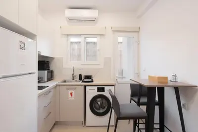 a kitchen with a washing machine and a table at 15 mins Walk to Acropolis, Minimalist Studio in Athens
