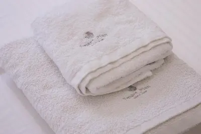 a stack of white towels sitting on a table at Panormou Neon - Urban Apartment 1A in Athens