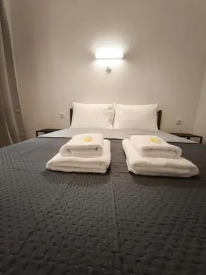 a bedroom with a bed with three towels on it at Beehive Mini Rooms in Athens