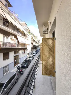 a balcony of a building with cars parked on a street at Beehive Mini Rooms in Athens