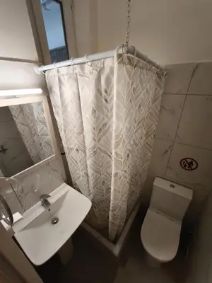 a bathroom with a sink and a toilet and a shower curtain at Beehive Mini Rooms in Athens