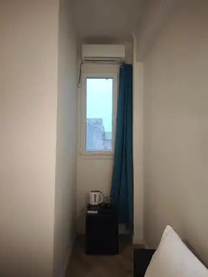a room with a window and a table and a bed at Beehive Mini Rooms in Athens