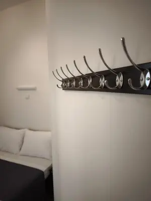 a shelf with glasses on a wall next to a bed at Beehive Mini Rooms in Athens
