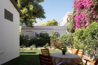 a table with a vase of flowers on top of a yard at Elaia House Glyfada in Athens