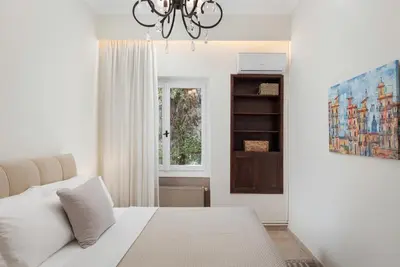a bedroom with a white bed and a window at Elaia House Glyfada in Athens