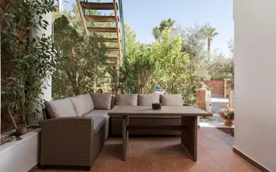 a patio with a couch and a table on a patio at Elaia House Glyfada in Athens