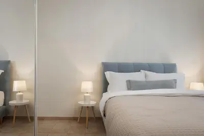 a bedroom with a blue bed with two lamps at Elaia House Glyfada in Athens