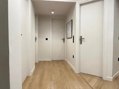 an empty hallway with white walls and wooden floors at New Sleek apartment in the center of AThens in Athens