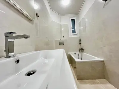 a white bathroom with a tub and a sink at New Sleek apartment in the center of AThens in Athens