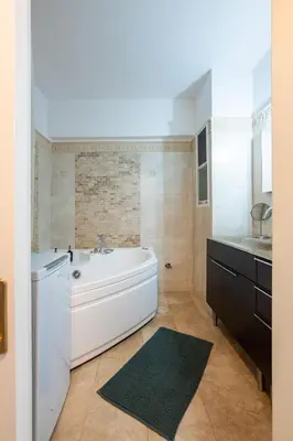 a bathroom with a white tub and a sink at Spacious 2BR, hot tub, prvt parking, near metro in Athens