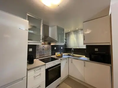 a kitchen with white cabinets and a stove top oven at Lemon & Roses in Athens