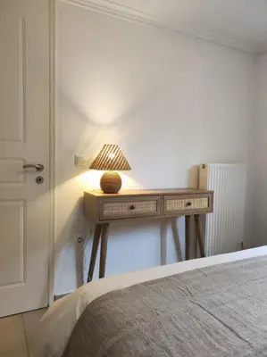 a bedroom with a table with a lamp on it at Lemon & Roses in Athens