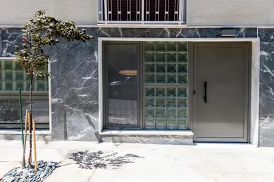 a door to a building with green glass panels at Glass Nest Athens 2BR Apartment near Metro & Airport Line in Athens