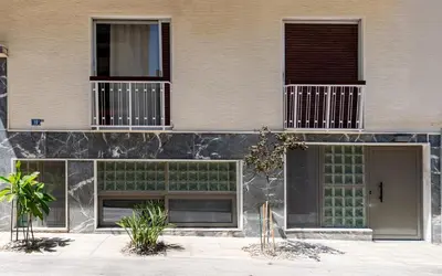 a building with two windows and a door at Glass Nest Athens 2BR Apartment near Metro & Airport Line in Athens