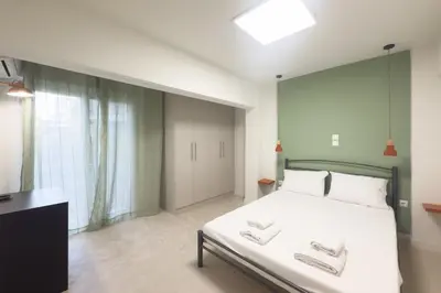 a bedroom with a large white bed and a window at Panormou Neon - Urban Apartment 1B in Athens