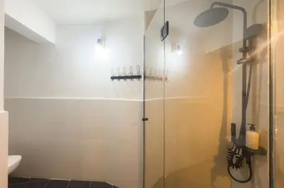 a bathroom with a shower with a glass door at Panormou Neon - Urban Apartment 1B in Athens