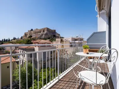a balcony with a table and chairs and a view at Phos, an eclectic suite with stunning Acropolis view in Athens