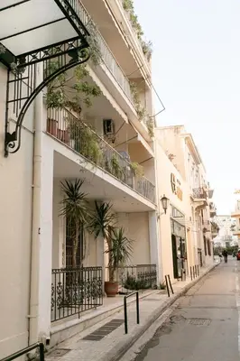 a building with potted plants on the side of a street at Phos, an eclectic suite with stunning Acropolis view in Athens