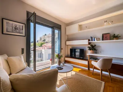 a living room with a couch and a table at Phos, an eclectic suite with stunning Acropolis view in Athens