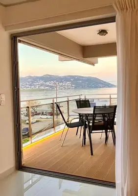 a view of a balcony with a table and chairs at Amelia luxury beachfront apartment near airport in Porto Rafti